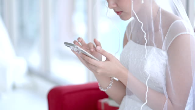 La-novia-examina-el-teléfono-celular-espera-de-tiempo-en-el-vestuario.