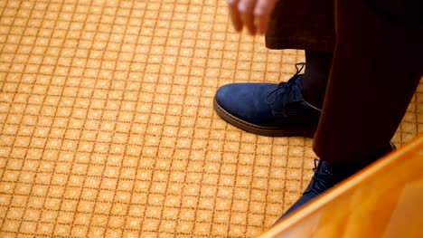 close-up,-men's-hands-tie-shoelaces.-man-is-putting-on-his-stylish-blue-suede-shoes,-on-carpet-background.-Groom-preparing-for-the-wedding