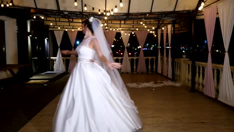 Winterabend,-eine-Terrasse-mit-Glühbirnen,-dekoriert-in-der-Straße-tanzen-das-Brautpaar-ihre-erste-Hochzeit-tanzen,-einen-Walzer.-Winter-Hochzeit