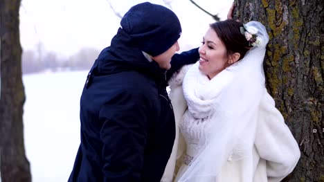 winter-wedding,-happy,-laughing-newlyweds-nice-talking.-frosty,-snowy-day,-on-the-bank-of-the-river,-on-the-embankment-of-the-city
