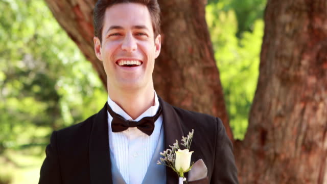 Happy-groom-laughing-and-smiling-at-camera