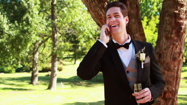 Glückliche-Bräutigam-trinkt-Champagner-und-plaudern-am-Telefon