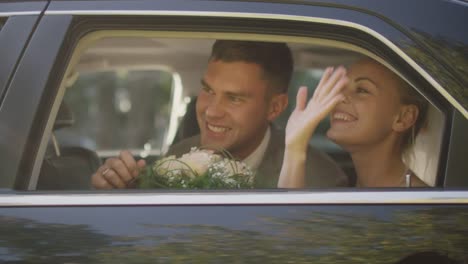 Newlyweds-arrive-in-a-black-car-and-kiss.