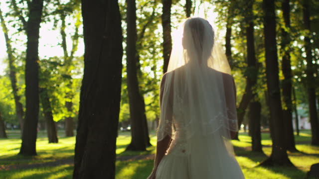 Braut-wirft-Blumenstrauß-bei-Hochzeit-in-sonnigem-Park