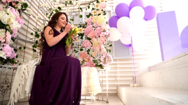 Mujer-joven-en-vestido-púrpura-se-encuentra-en-Banco-de-boda-con-flores
