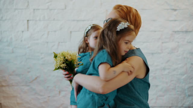 Mother-and-two-little-daughters-are-hugging-each-other