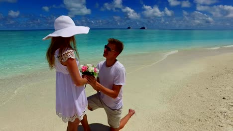 v07388-Maldives-white-sandy-beach-2-people-young-couple-man-woman-proposal-engagement-wedding-marriage-on-sunny-tropical-paradise-island-with-aqua-blue-sky-sea-water-ocean-4k