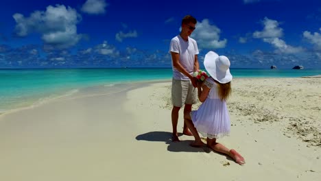 v07383-Maldives-white-sandy-beach-2-people-young-couple-man-woman-proposal-engagement-wedding-marriage-on-sunny-tropical-paradise-island-with-aqua-blue-sky-sea-water-ocean-4k