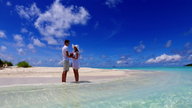 v07381-Maldives-white-sandy-beach-2-people-young-couple-man-woman-proposal-engagement-wedding-marriage-on-sunny-tropical-paradise-island-with-aqua-blue-sky-sea-water-ocean-4k