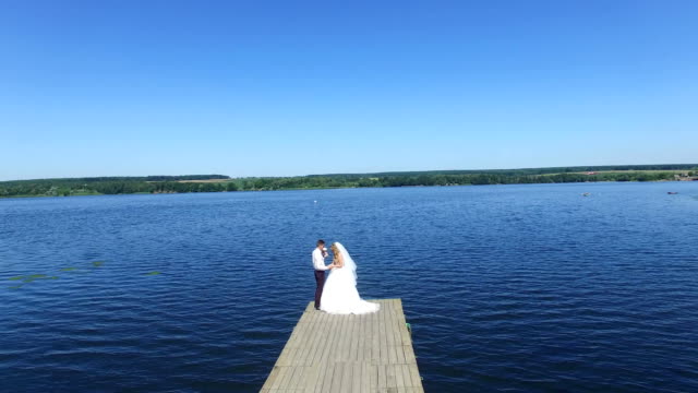 Hochzeit-paar-posiert-auf-See-Hintergrund
