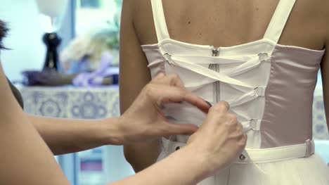 Tying-a-white-corset-on-beautiful-dress