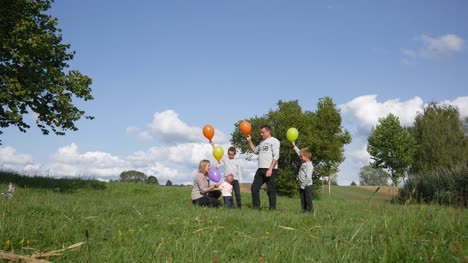 Familie-startet-Ballons-auf-dem-Rasen