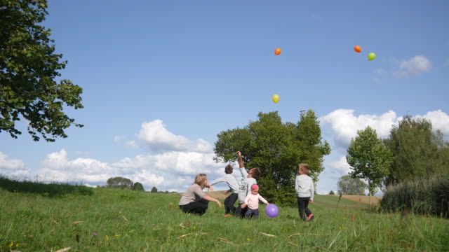 Familie-startet-Ballons-auf-dem-Rasen