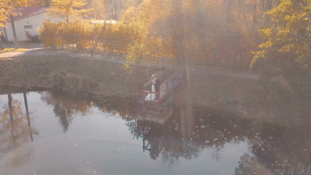 Junge-Brautpaar-steht-auf-einer-kleinen-Brücke-in-der-Nähe-von-schönen-See