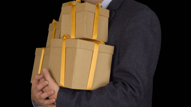 Caucasian-man-in-classic-suit-stand-and-hold-many-gift-boxes.-Brown-gift-box.-Businessman-present-gifts-on-holiday-eve.-Alpha-channel-chroma-key-transparent-background.-Locked-down.