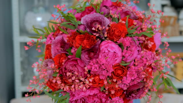 Professionellen-Floristen-halten-und-zeigen-Blumenstrauß-im-studio