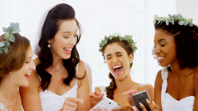 Bride-and-bridesmaids-laughing-at-there-photos-4K-4k