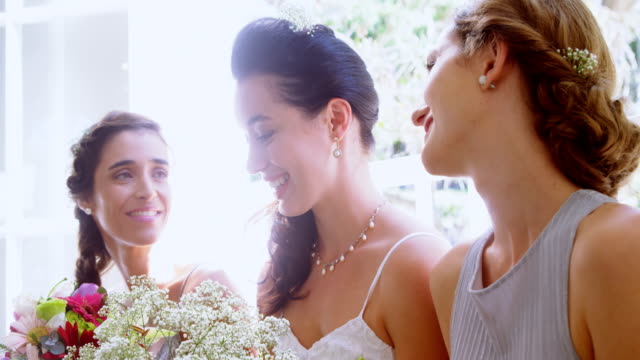 Bridesmaids-and-bride-looking-at-each-other-happily-4K-4k