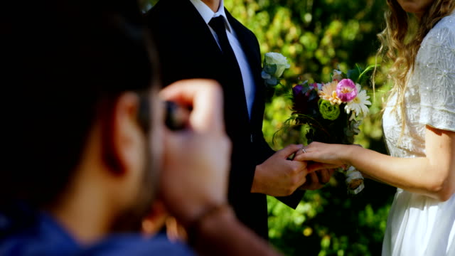 Groom-holding-bride-hand-and-photographer-taking-photo-4K-4k