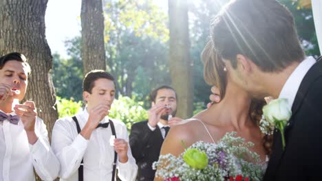 Braut-und-Bräutigam-küssen-einander-im-Hintergrund-Gast-bläst-Luftblasen-4K-4k