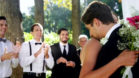Bride-and-groom-happily-hugging-each-other-and-guests-clapping-4K-4k