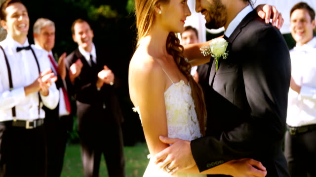 Bride-and-groom-embracing-and-guest-applauding-in-background-4K-4k