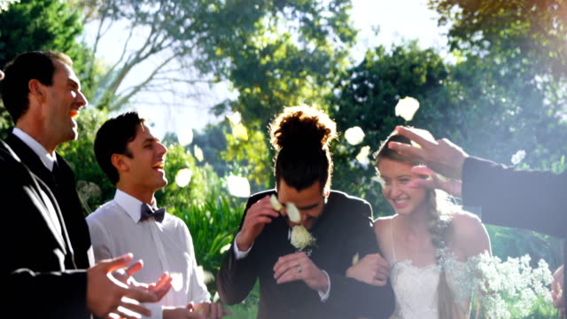 Braut-und-Bräutigam-zu-Fuß-nach-unten-während-Gäste-werfen-Blütenblätter-4K-4k