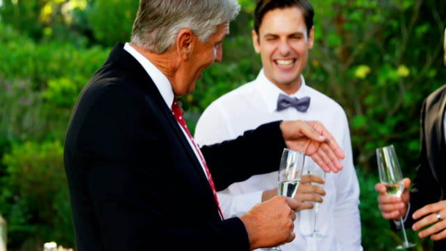 Father-of-the-Bride-toasting-champagne-with-groom-and-guest-4K-4k