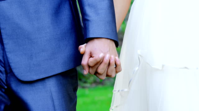 Bride-and-groom-holding-hands-at-wedding-4K-4k