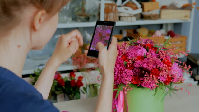 Woman-taking-photo-of-beautiful-bouquet-with-smartphone.