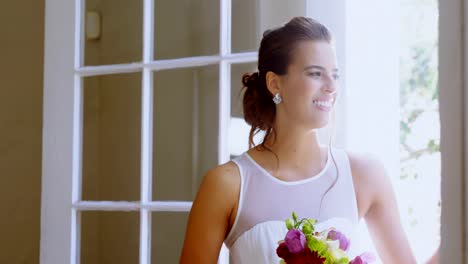 Bride-standing-near-the-window-with-a-bouquet-4K-4k