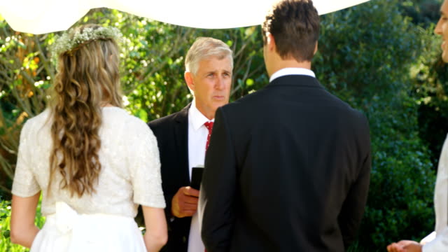 Priest-talking-to-the-bride-and-groom-4K-4k