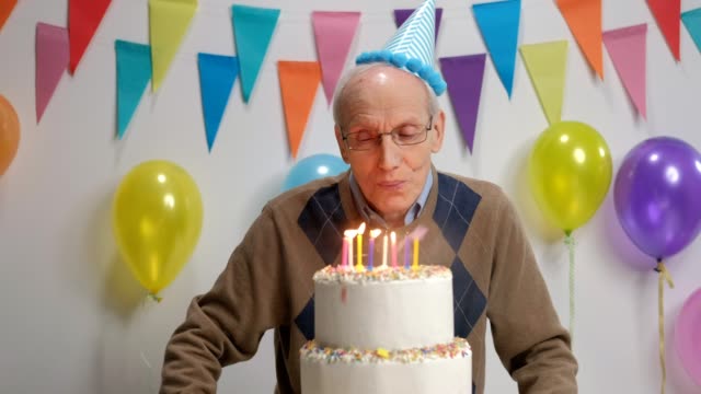 Senior-soplando-velas-en-una-torta-de-cumpleaños