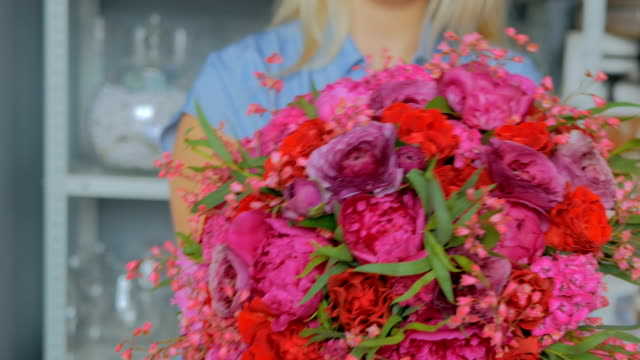 Professionellen-Floristen-halten-und-zeigen-Blumenstrauß-im-studio