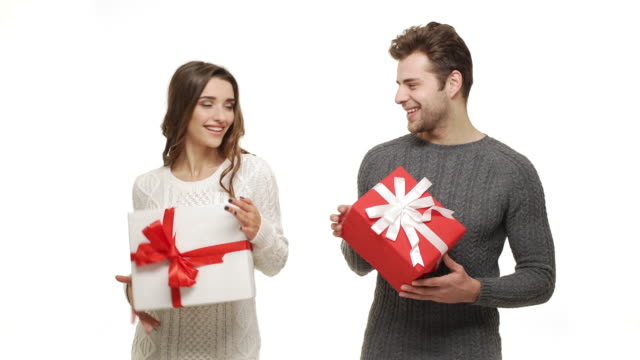 4k-Young-couple-showing-and-exchanging-presents-in-Chrismas-day-on-white-background.