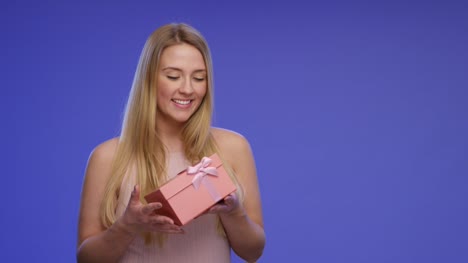 Schöne-junge-Frau-hält-ein-Geschenk-Box-in-ihren-Händen-auf-Bluescreen