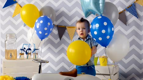 Cute-1-year-boy-is-celebrating-his-one-year's-birthday-with-balloons.