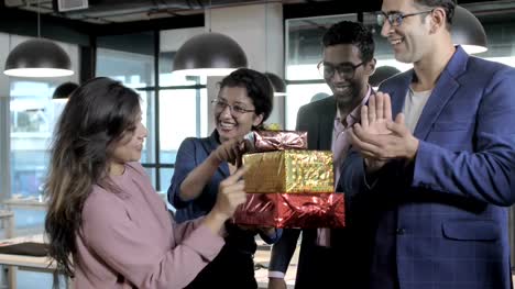 office-colleagues-smiling,-clapping-and-celebrating-success-by-giving-gift-boxes
