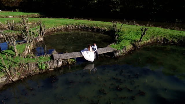 Las-novias-se-sientan-cerca-del-lago-en-un-pequeño-puente-en-el-Parque