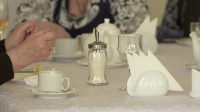 Seniors-sitting-around-dinner-table-eating-cake