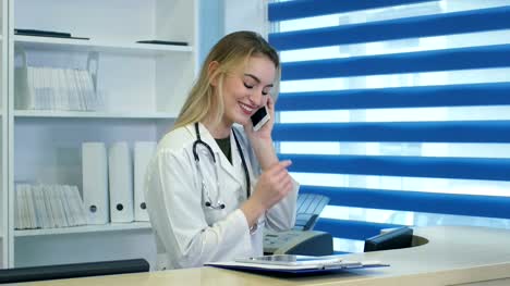 Hübsche-Krankenschwester-mit-Tablet-und-Smartphone-an-Krankenhaus-Rezeption