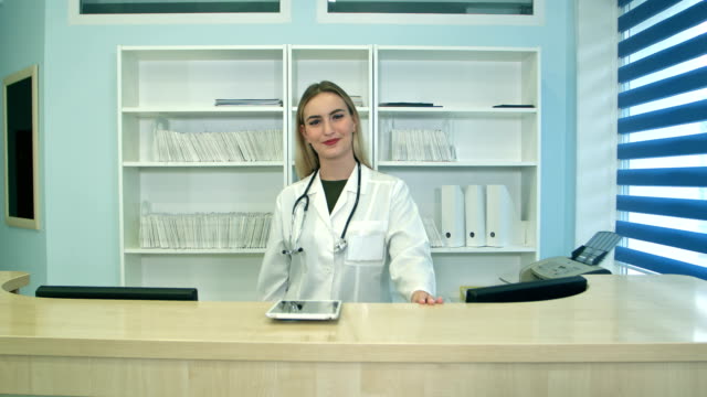Sonriente-mujer-médico-en-la-recepción-mirando-a-la-cámara