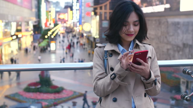 Junge-asiatische-Frau-mit-smartphone-in-der-Stadt