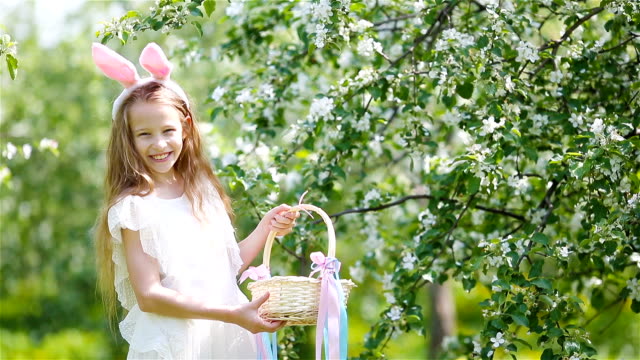 Adorable-little-girl-in-blooming-apple-garden-on-beautiful-spring-day