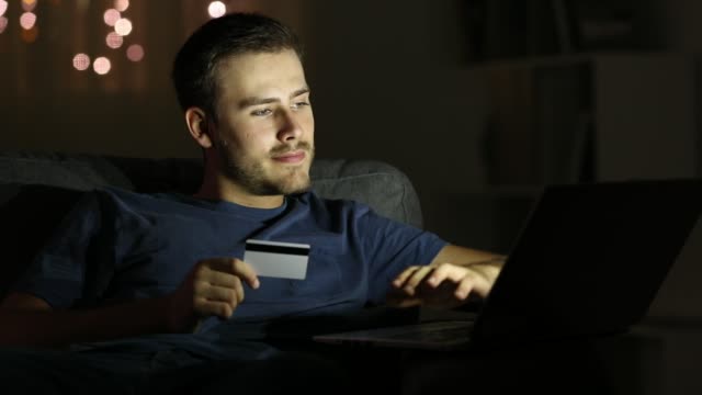 Glücklicher-Mann-online-mit-Kreditkarte-zu-bezahlen,-in-der-Nacht