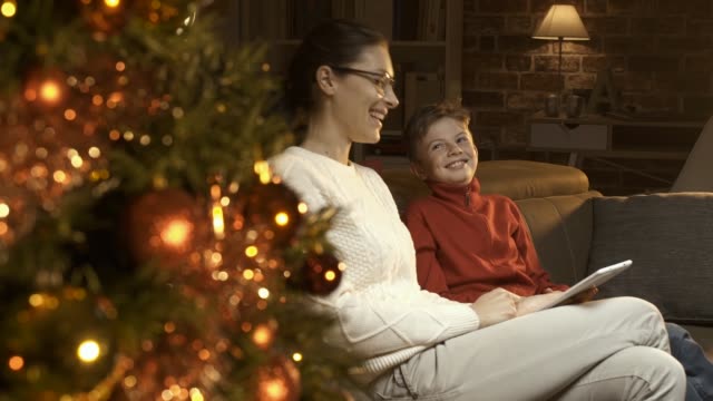 Junge-und-seine-Mutter-mit-einem-digital-Tablette-zusammen-auf-Weihnachten