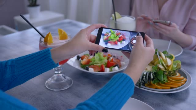 nützlichen-Essen,-Arm-der-Blogger-Frau-mit-Handy-für-Foto-des-vegetarischen-Essens-während-gesundes-Mittagessen-für-soziale-Netzwerke
