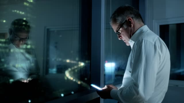 Glücklich-Manager-mit-Smartphone-im-dunklen-Büro-in-der-Nacht