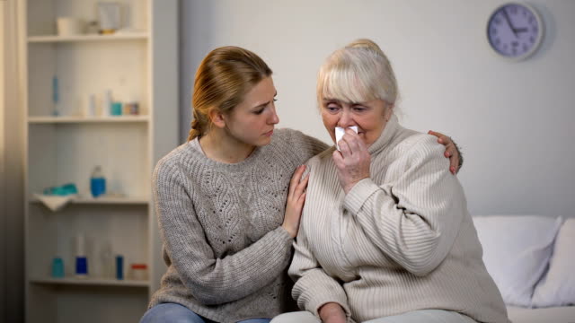 Enkelin-umarmt-und-weinenden-Großmutter,-unheilbare-Krankheit-zu-unterstützen