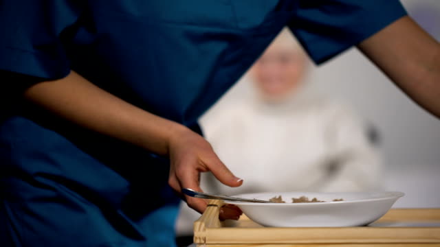 Medizinische-Arbeiter-im-Alter-von-Patienten,-sanft-Pflege-im-Pflegeheim-Abendessen-bringen